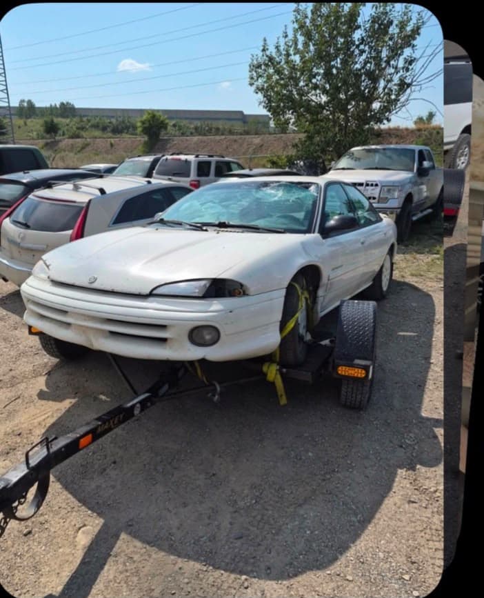 Damaged sedan being assessed for scrap value